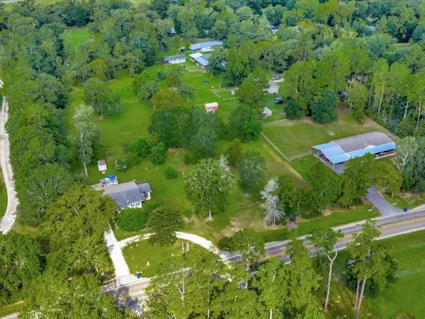 an aerial view of residential houses with outdoor space and trees