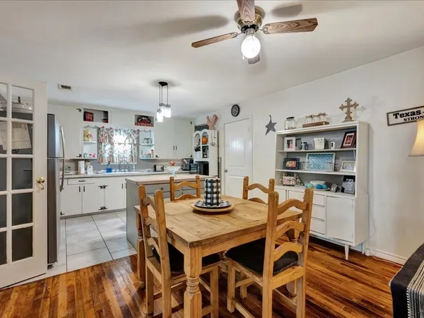 a kitchen with a dining table cabinets stainless steel appliances and dining table