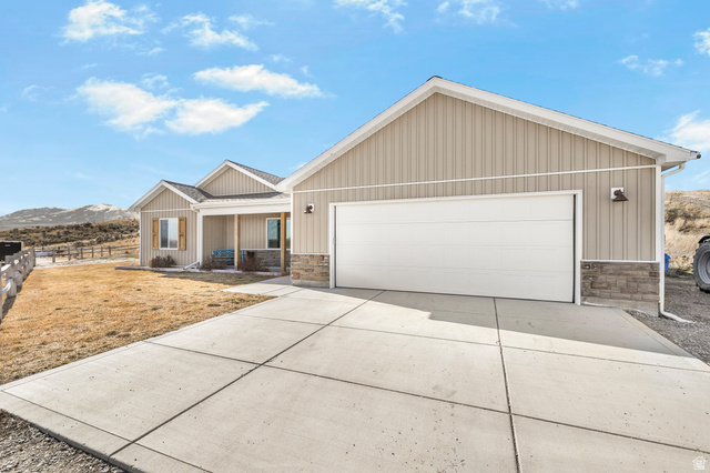 18573 South Marsh Valley Road Downey, ID 83234 - Photo 2 of 32 View of front of house with stone siding, a porch, driveway, and a mountain view