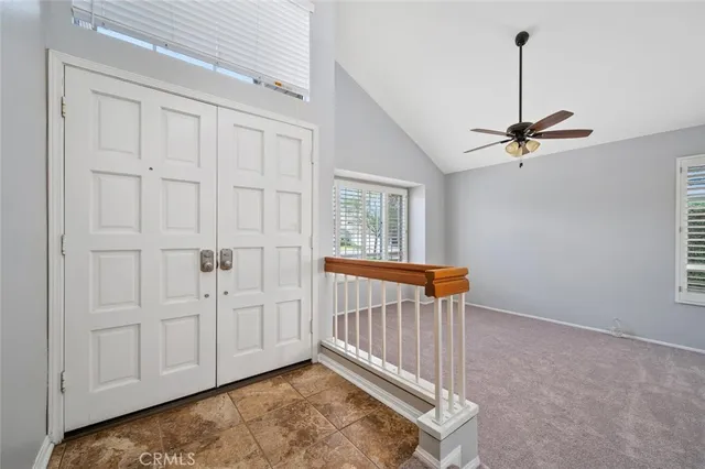 an empty room with windows and fan
