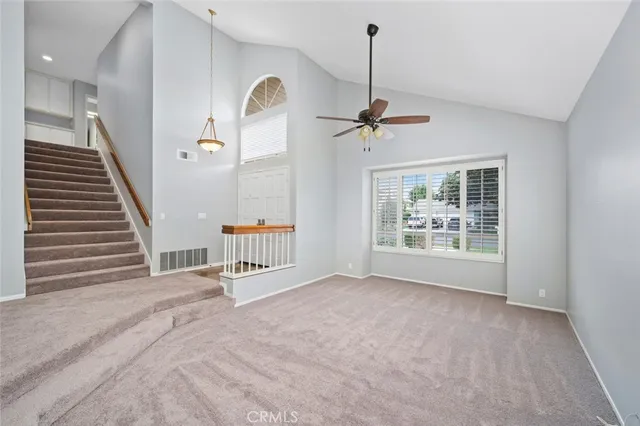 a view of an empty room with a window and chandelier