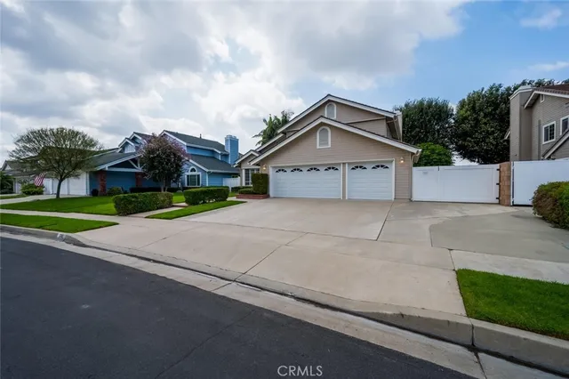 a view of a house with a yard and large trees