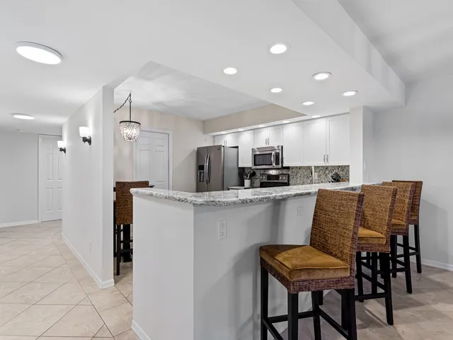 a kitchen with kitchen island wooden cabinets and refrigerator