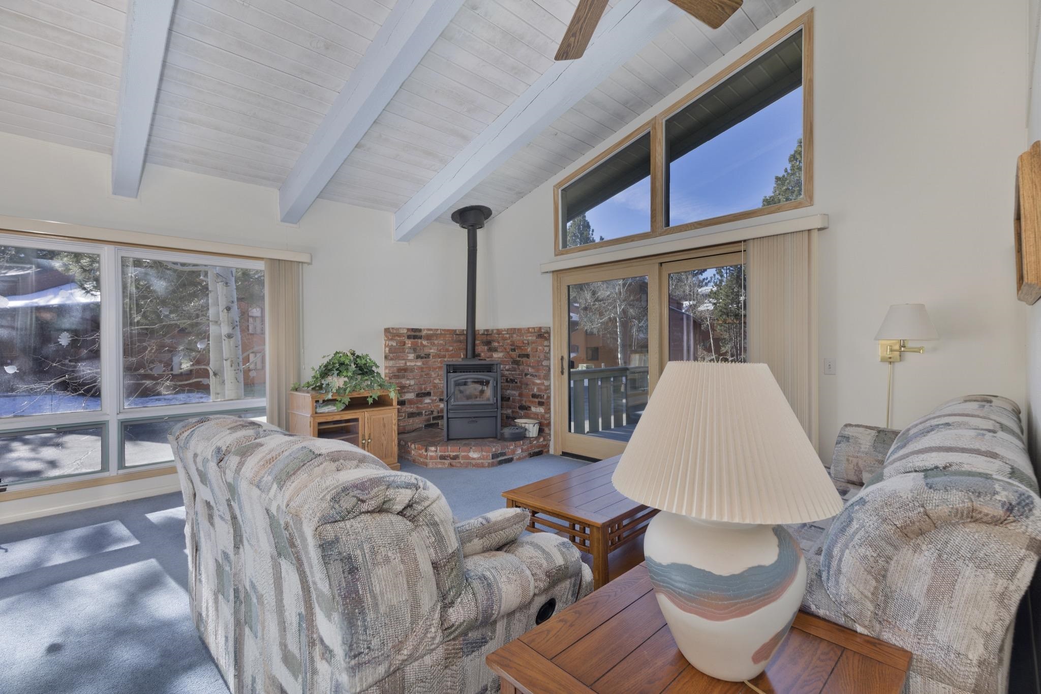 3251 Chateau Road, Unit 40 Mammoth Lakes, CA 93546 - Photo 3 of 31 Living room with a wood stove, vaulted ceiling, ceiling fan, and carpet flooring