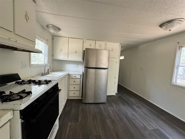 a kitchen with a refrigerator and a stove top oven