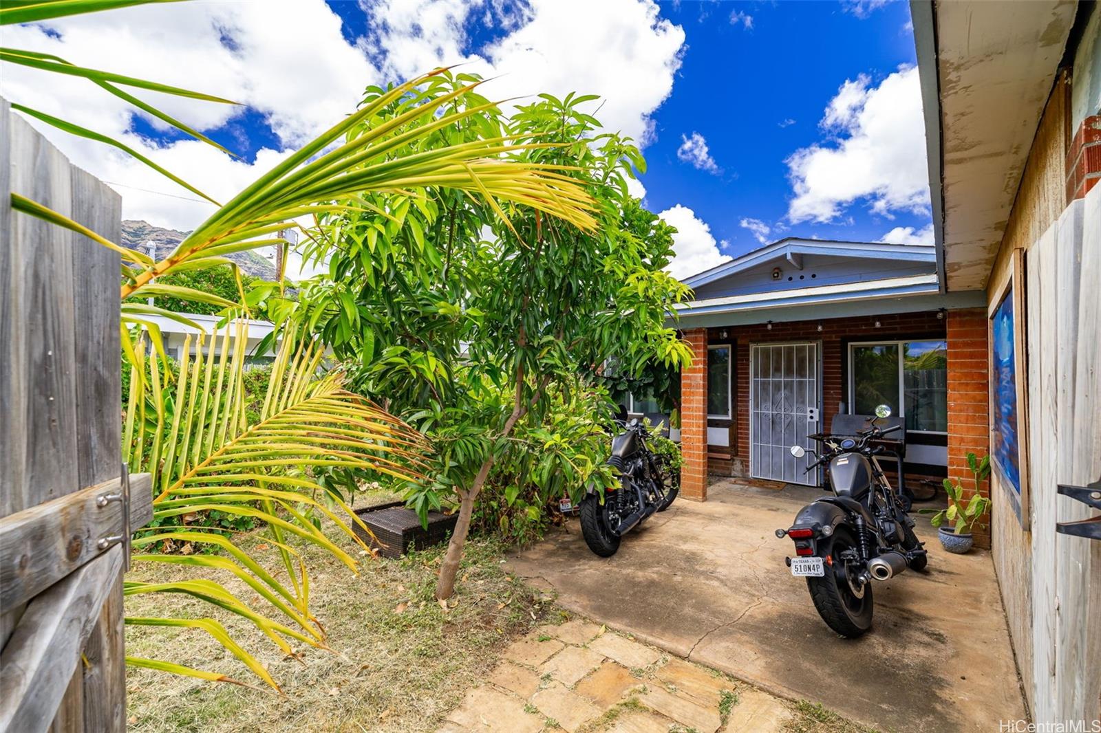 85-491 Waianae Valley Road Waianae, HI 96792 - Photo 1 of 1 a view of a chair and tables in the patio in front of a house