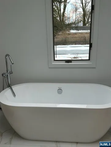 a white bath tub sitting next to a window