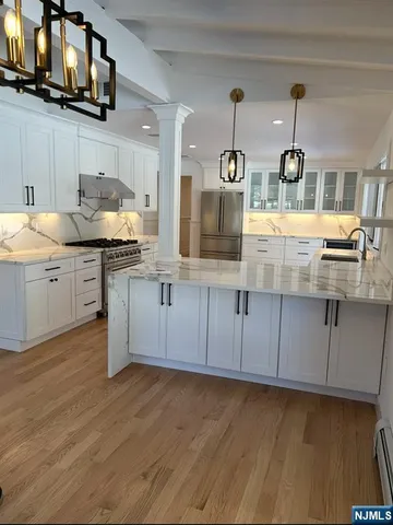 a kitchen with stainless steel appliances granite countertop a stove a sink and a microwave