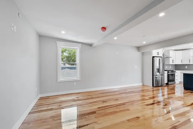 a view of a kitchen with stainless steel appliances a window and a fireplace