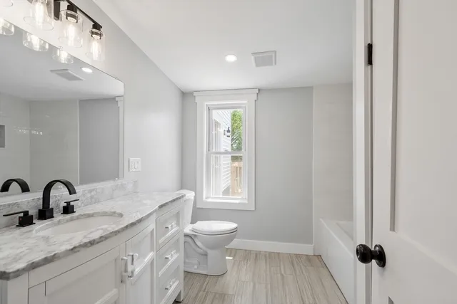 a bathroom with a granite countertop sink toilet and shower