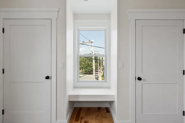 a view of a hallway that has a white door and a window