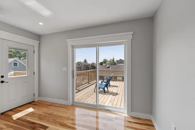 a view of a livingroom with wooden floor and a floor to ceiling window