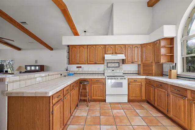 a kitchen with a sink stove top oven and cabinets