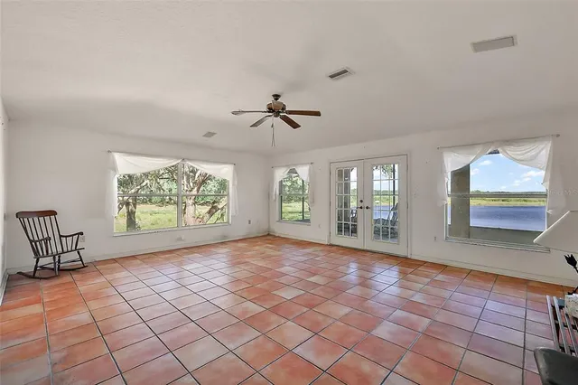 an empty room with windows and fan