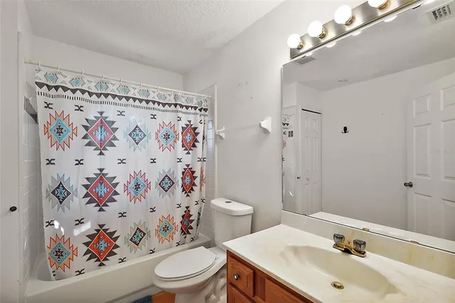 a bathroom with a sink a toilet and shower curtain