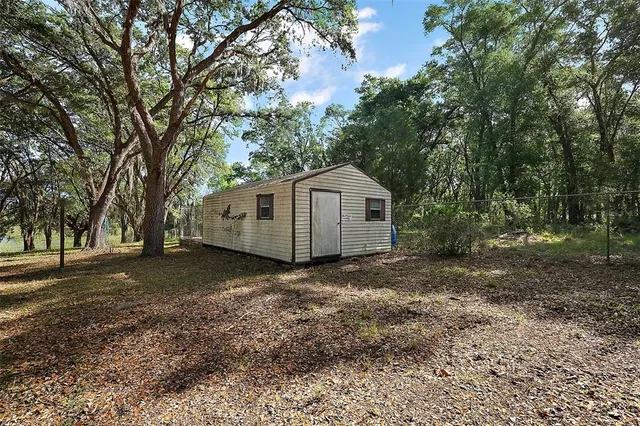 a view of a house with a large tree and a yard