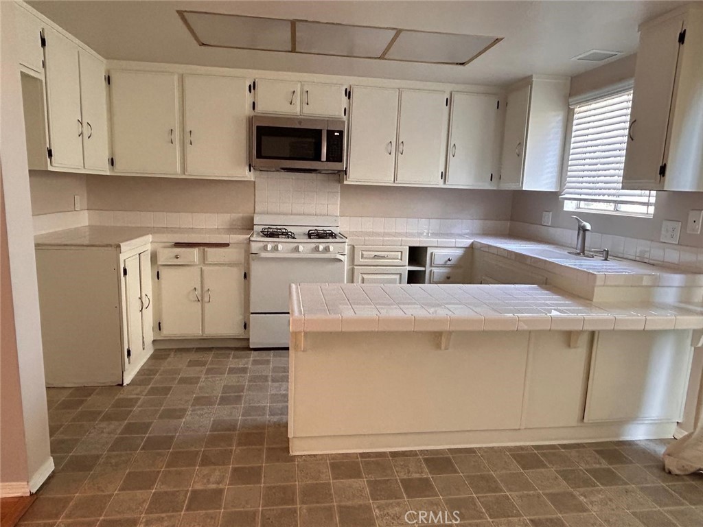 427 East Park Avenue, Unit 2 Santa Maria, CA 93454 - Photo 4 of 12 a kitchen with stainless steel appliances granite countertop a sink a stove and a microwave