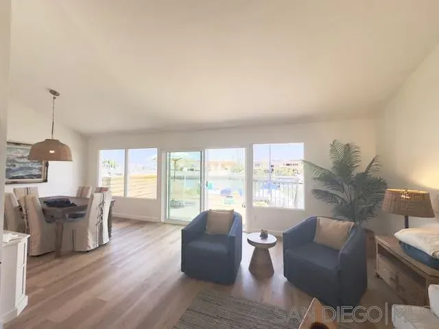 a living room with furniture and floor to ceiling windows