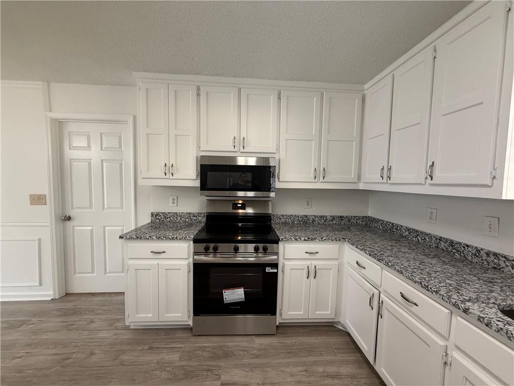 2540 Fortune Drive Dacula, GA 30019 - Photo 13 of 54 a kitchen with granite countertop white cabinets and stainless steel appliances