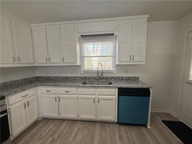 a kitchen with stainless steel appliances granite countertop a refrigerator sink and white cabinets