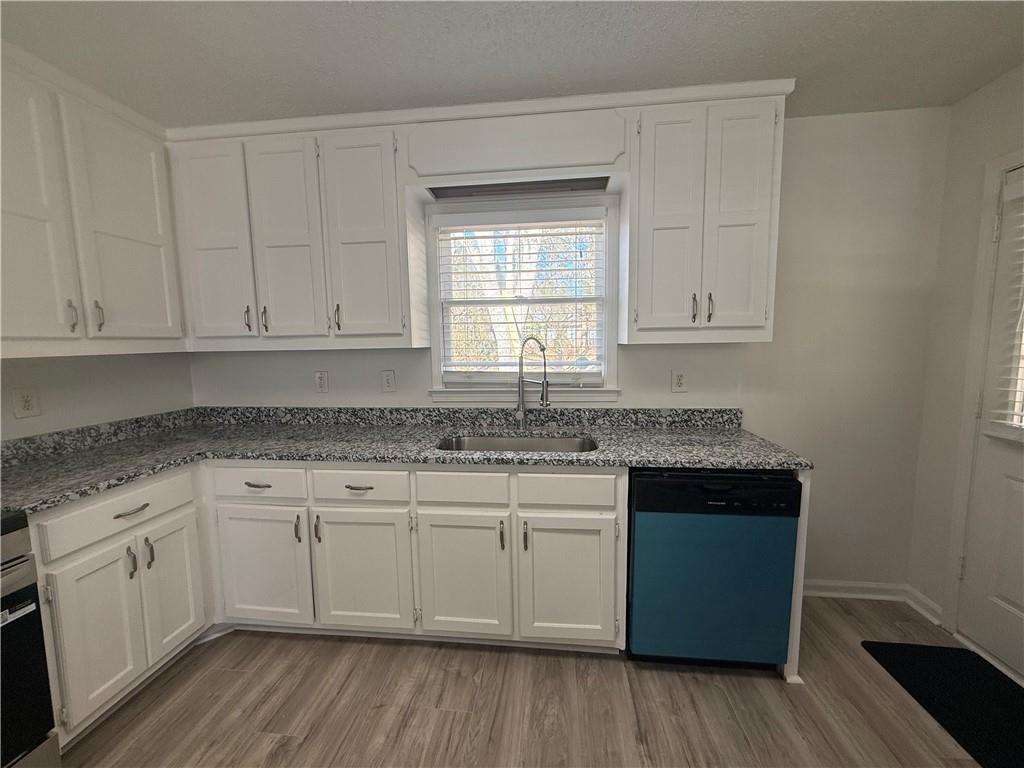 2540 Fortune Drive Dacula, GA 30019 - Photo 14 of 54 a kitchen with stainless steel appliances granite countertop a sink stove and cabinets with wooden floor