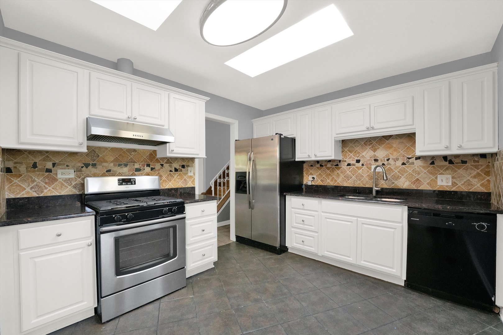7133 Edgebrook Lane Hanover Park, IL 60133 - Photo 8 of 26 a kitchen with stainless steel appliances white cabinets and a stove top oven