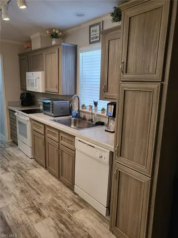 a kitchen with a sink a refrigerator a washer dryer and cabinets