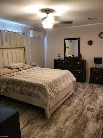 a bedroom with a bed and a tv on the dresser