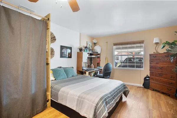 a bedroom with a bed and wooden floor