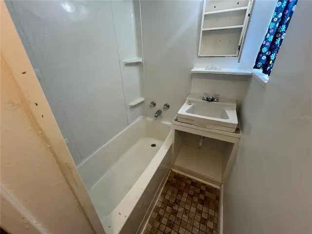 a bathroom with a tub sink and vanity