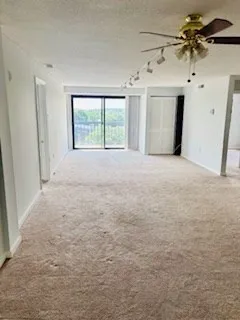 a view of a livingroom with a ceiling fan and window