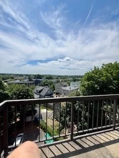 a view of a balcony with wooden floor & fence