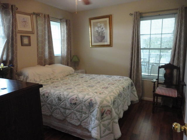 6404 Old River Road Baker, FL 32531 - Photo 14 of 28 a bedroom with a bed and a chair with the wooden floor