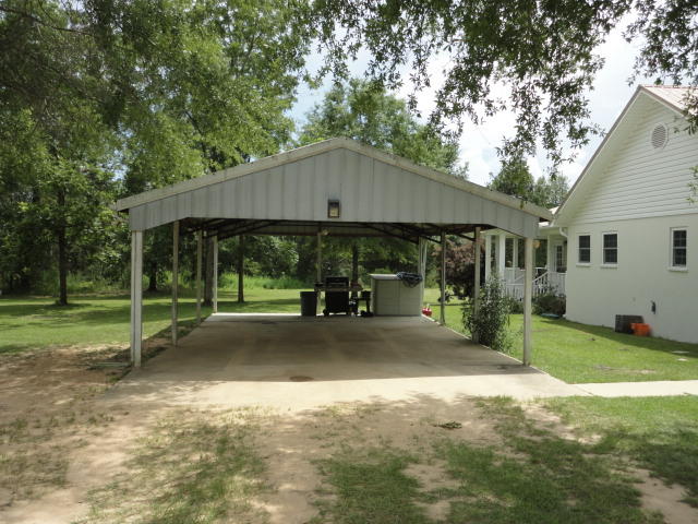 6404 Old River Road Baker, FL 32531 - Photo 9 of 28 a backyard of a house with garden and barbeque oven