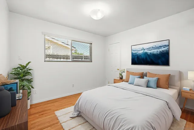 a bedroom with a large bed and a potted plant