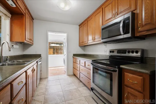 a kitchen with stainless steel appliances granite countertop a stove microwave and sink