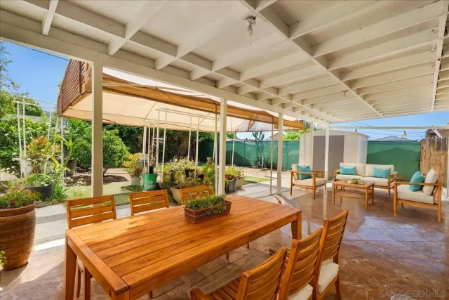 a view of a patio with a table chairs and a backyard