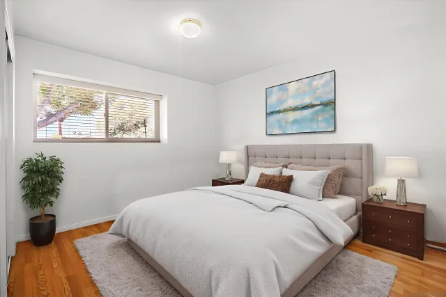 a bedroom with bed and a potted plant