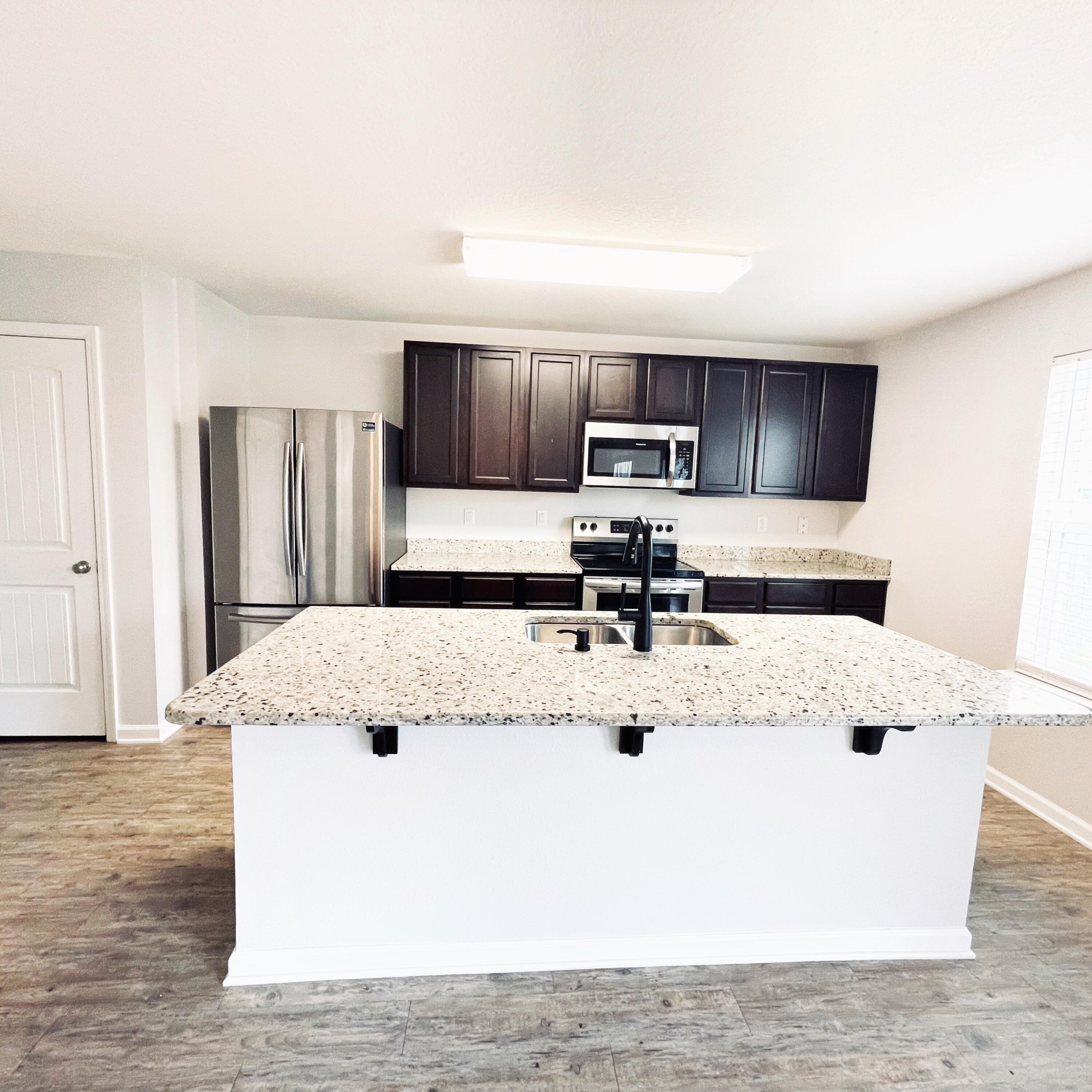745 Widgeon Way Crestview, FL 32539 - Photo 14 of 17 a large kitchen with kitchen island sink and refrigerator