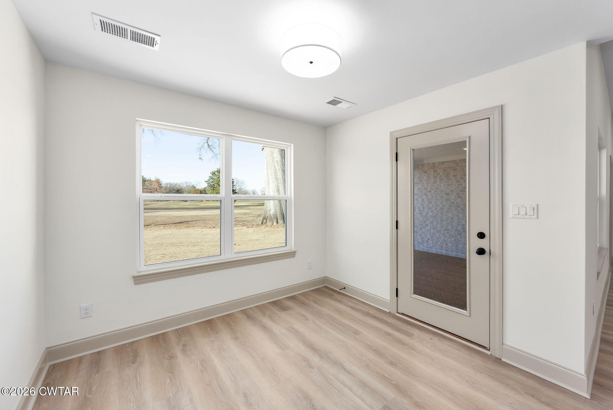 77 Grande Pnes Cove Jackson, TN 38305 - Photo 11 of 31 an empty room with wooden floor and windows