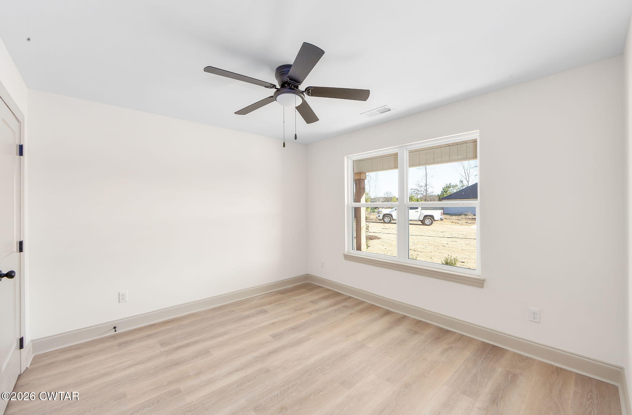 77 Grande Pnes Cove Jackson, TN 38305 - Photo 16 of 31 an empty room with wooden floor fan and windows