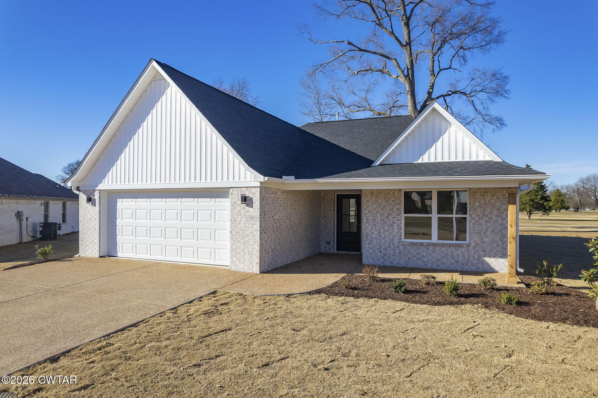 77 Grande Pnes Cove Jackson, TN 38305 - Photo 2 of 31 a front view of a house with a yard and garage