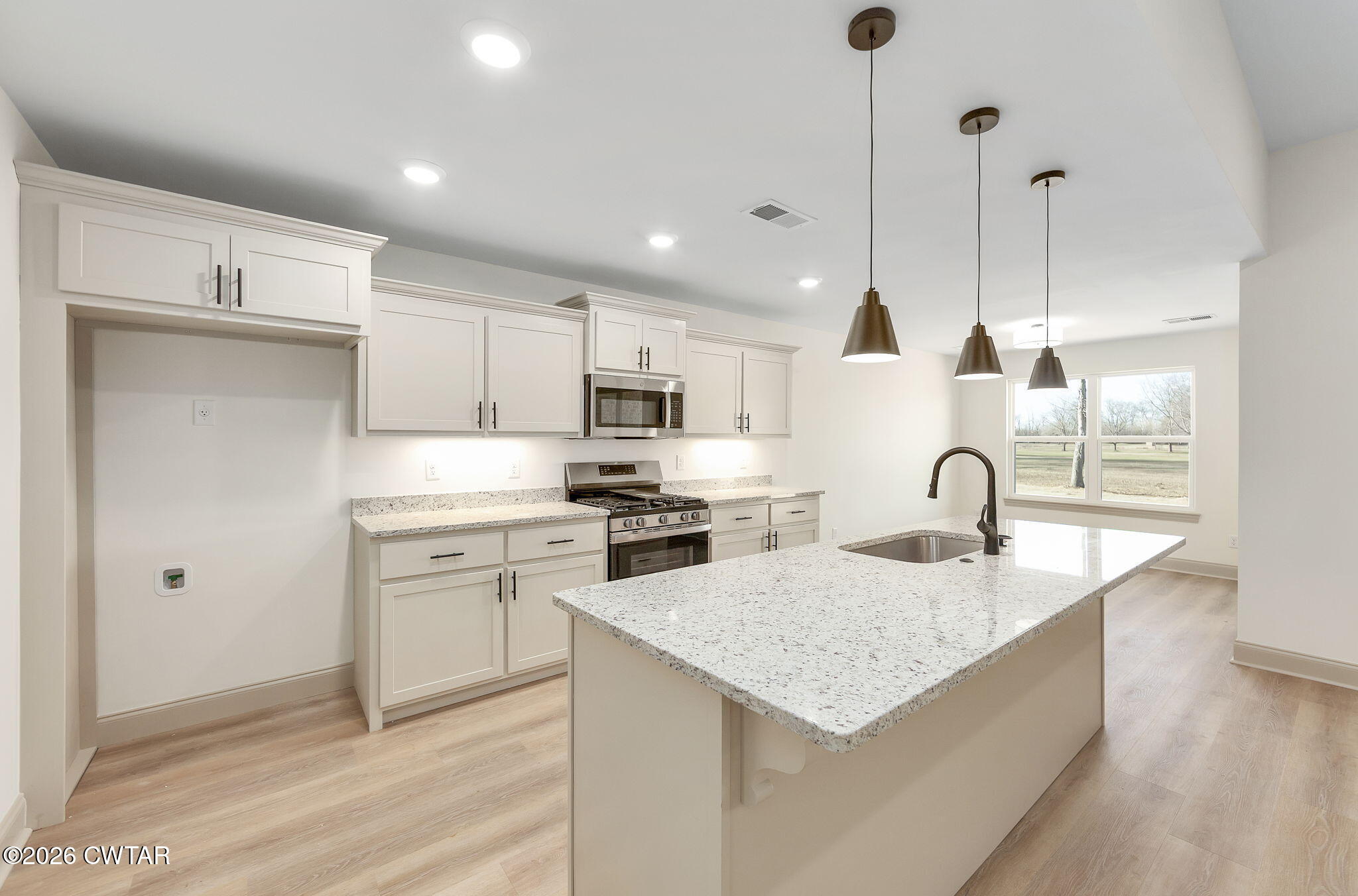 77 Grande Pnes Cove Jackson, TN 38305 - Photo 5 of 31 a kitchen with stainless steel appliances granite countertop a sink a stove a refrigerator and white cabinets with wooden floor