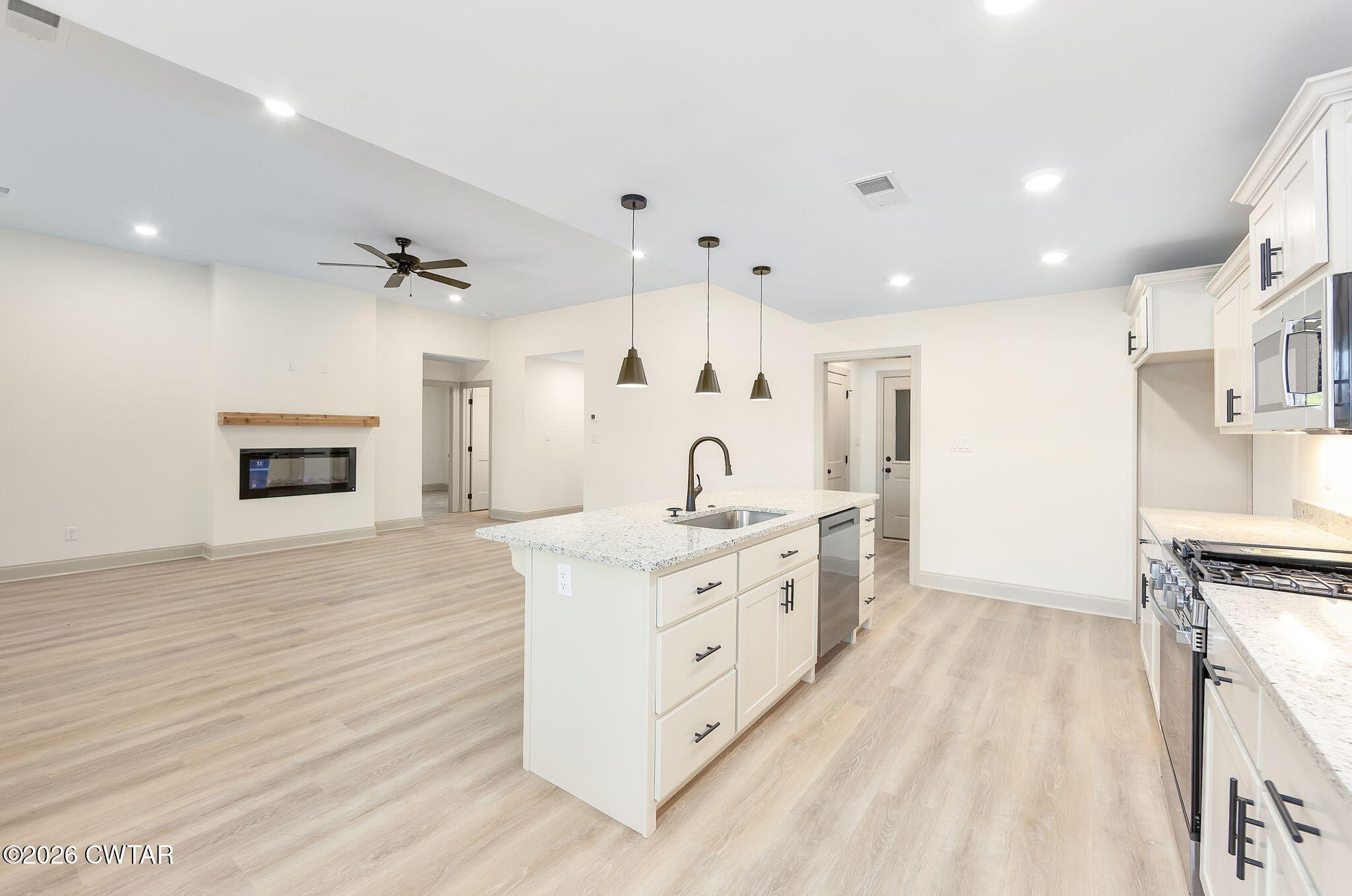 77 Grande Pnes Cove Jackson, TN 38305 - Photo 9 of 31 a large white kitchen with cabinets a sink and a stove