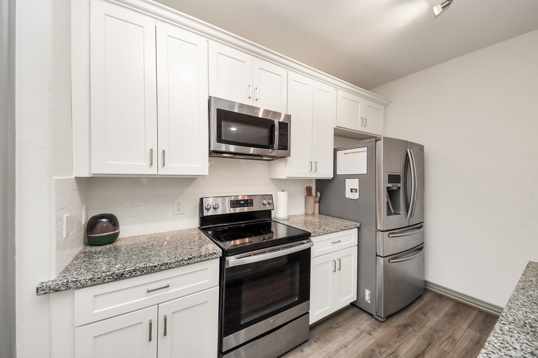 5334 Pershing Street Houston, TX 77033 - Photo 30 of 43 a kitchen with stainless steel appliances granite countertop white cabinets a sink a stove and a microwave