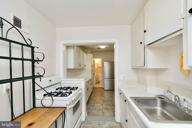 a kitchen with a stove a sink and a refrigerator