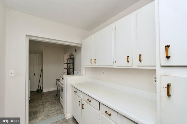 a view of a kitchen with white cabinets and a sink