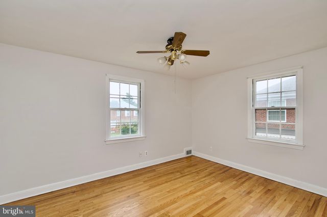 an empty room with a window and wooden floor