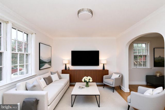 a living room with furniture a flat screen tv and a window