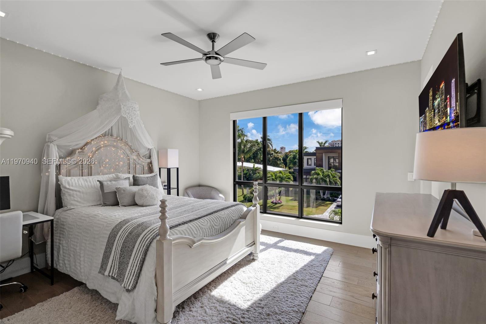 225 Northeast 3rd Street Boca Raton, FL 33432 - Photo 25 of 36 a bedroom with a balcony a bed and a large window